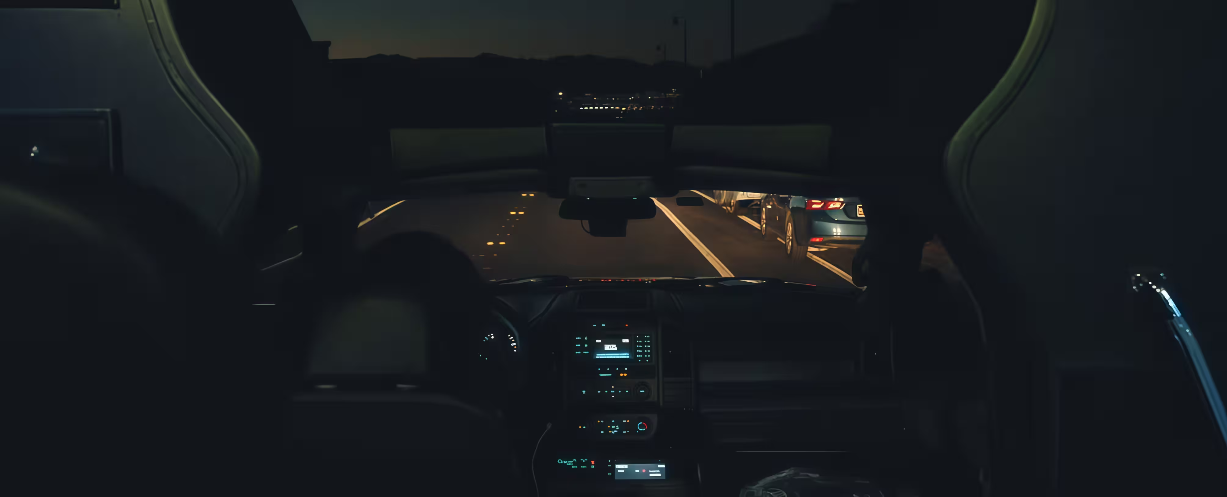 View from the driver's seat of a chauffeured vehicle on a Las Vegas road at night.